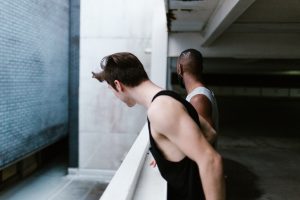 Two men looking over a concrete balcony