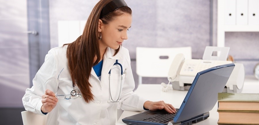 Young female physician using laptop to access eConsult