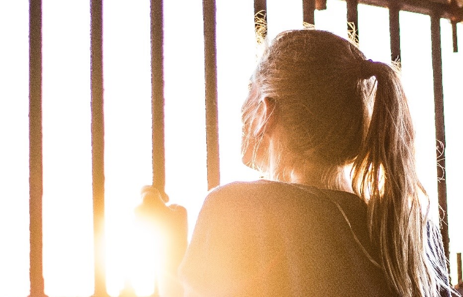 Image of a woman standing at bars