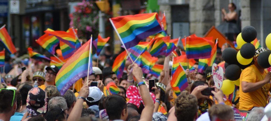 People celebrating and waving flags at Toronto's annual Pride Parade