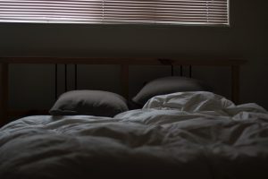 An unmade bed with two pillows