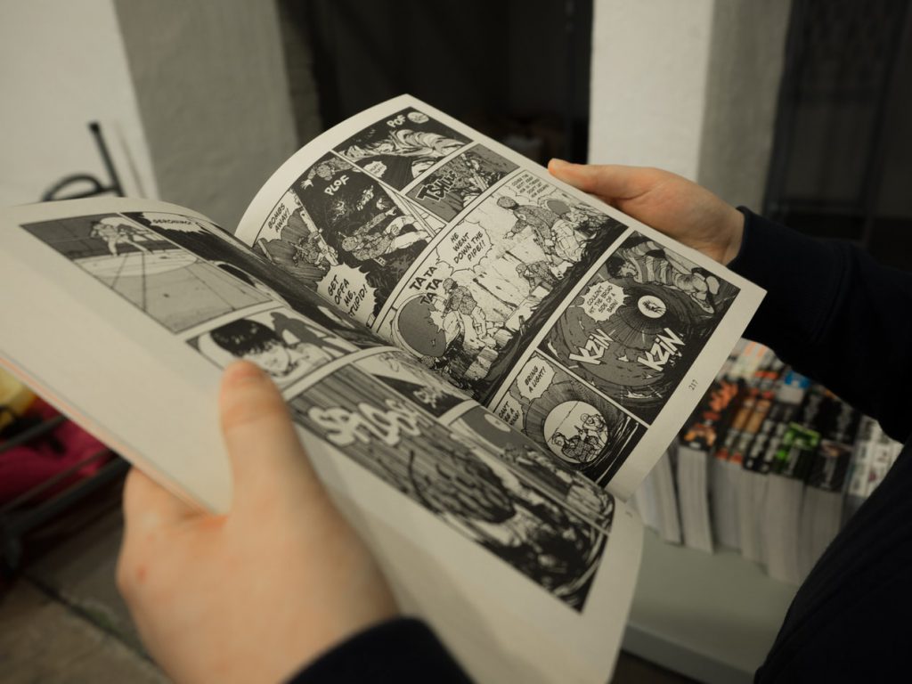 An open comic book being read by a person