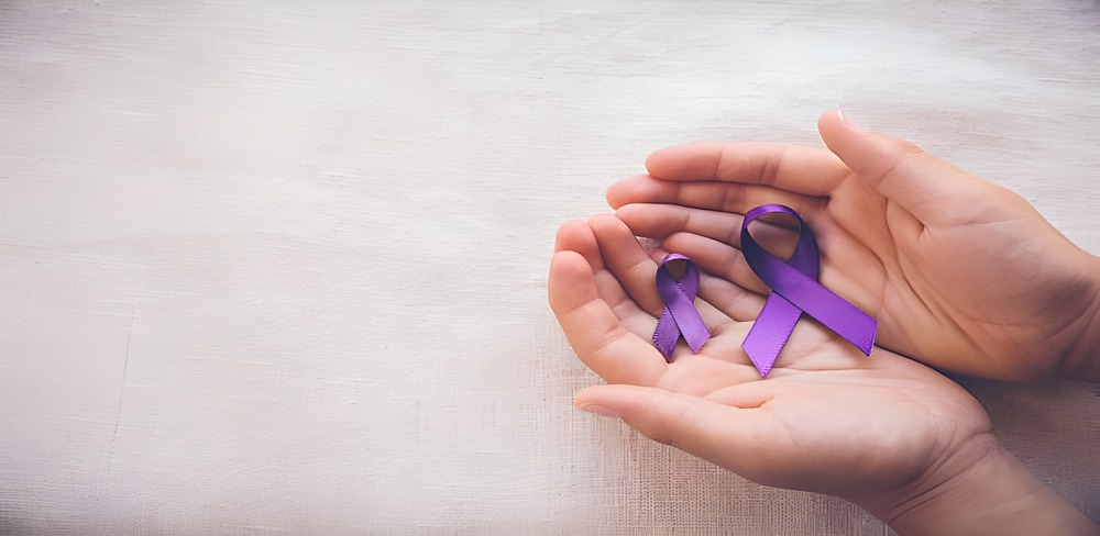 Two hands holding two purple awareness ribbons